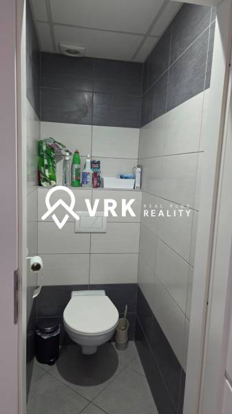 A toilet with tiles and storage space in a 3-room apartment.