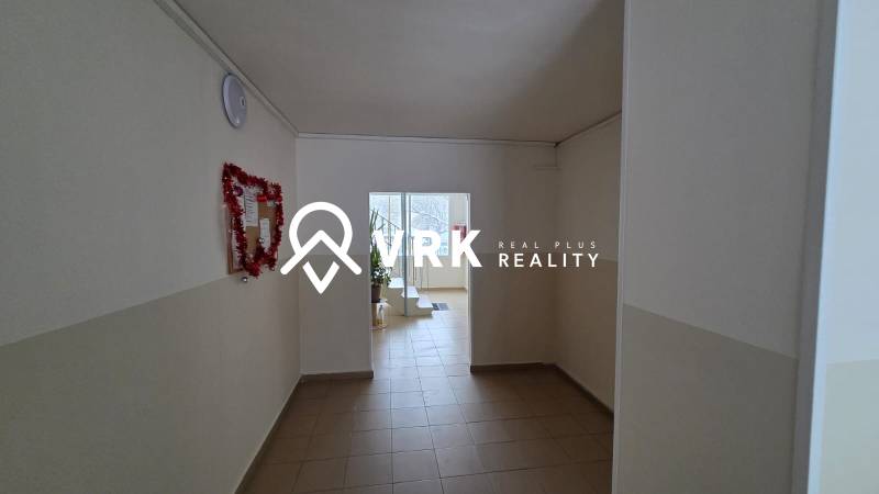 A hallway with white walls and light tiles in a 3-room apartment.