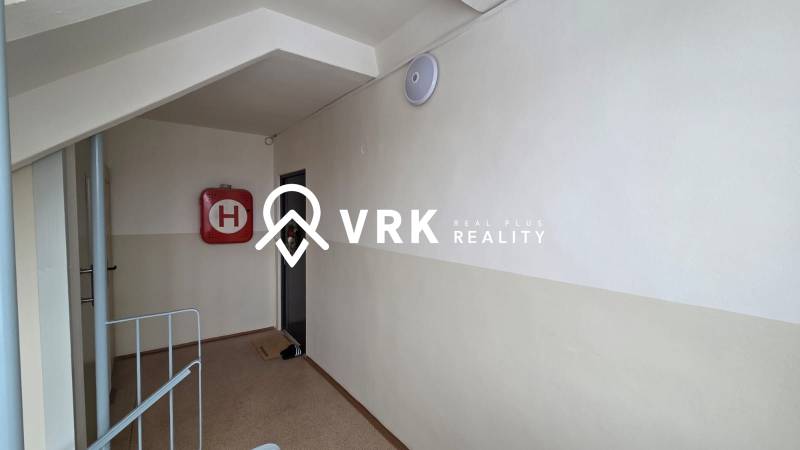 A corridor to a 3-room apartment with a fire hydrant and light.