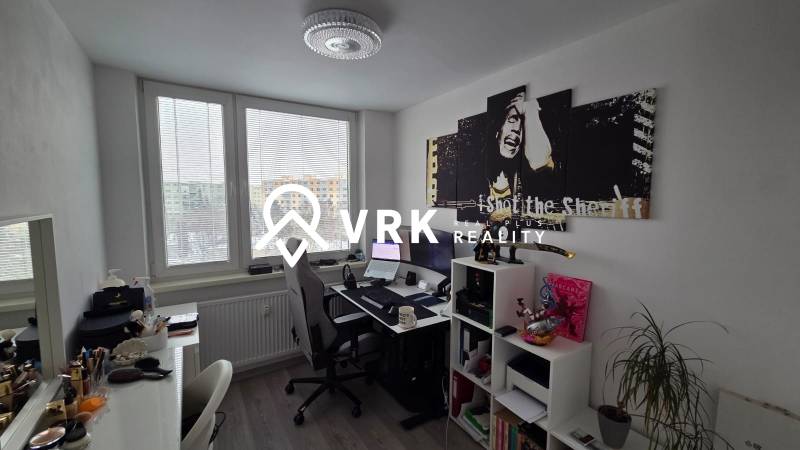 A study in a 3-room apartment with a desk, a shelf, a painting, and a floor with a wooden decor.