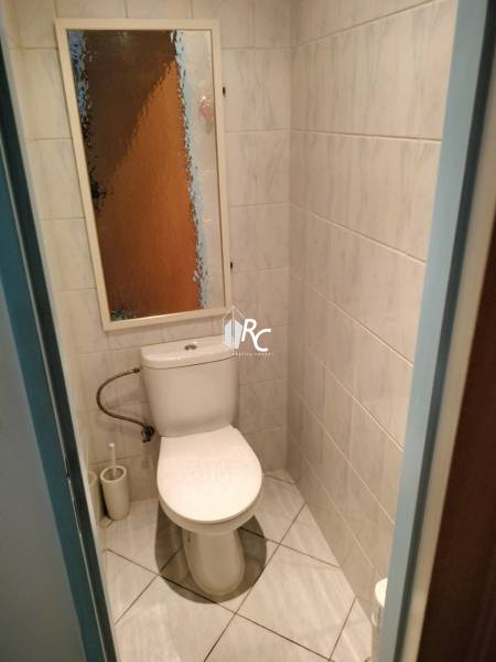 Bathroom with tiles and toilet in a 2-room apartment.