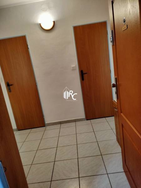 Entrance hallway in a 2-room apartment with tiles and wooden doors.