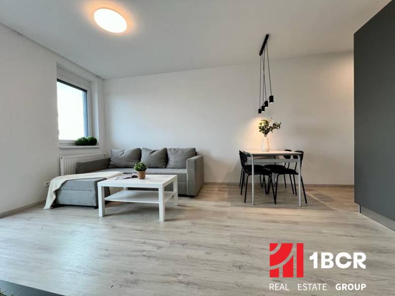 2-room apartment with a comfortable sofa, table, and floor with a wooden decor.