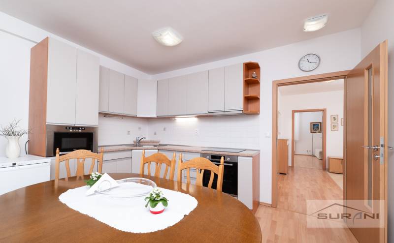 Dining room in a 3-room apartment with a kitchen unit and a wooden decor floor.