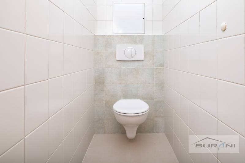 A toilet with tiles and a wall-hung toilet in a 3-room apartment.