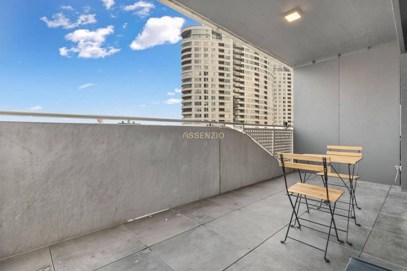 A balcony with modern furniture, overlooking high-rise buildings in Bratislava - Nové Mesto.