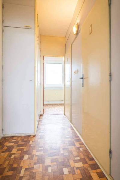 A hallway in a 2-room apartment with a parquet floor and built-in wardrobes.