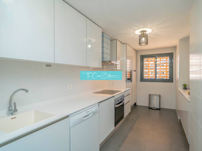 A bright kitchen with modern appliances in a two-room apartment, floor with wooden decor.