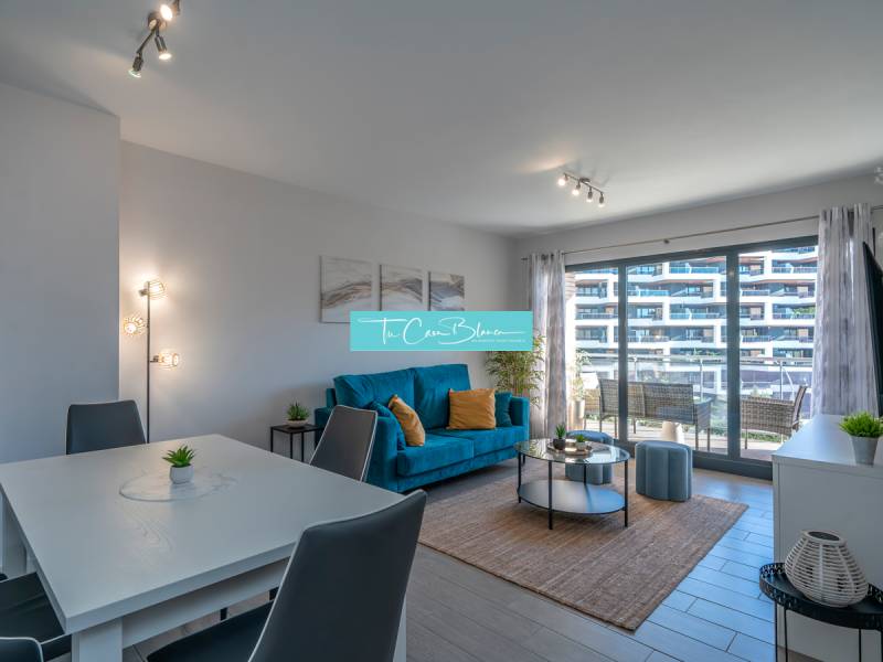 Living room in a two-room apartment with a wooden decor floor and seating area.