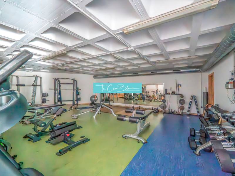 Gym with machines and a mirror in a 2-room apartment.