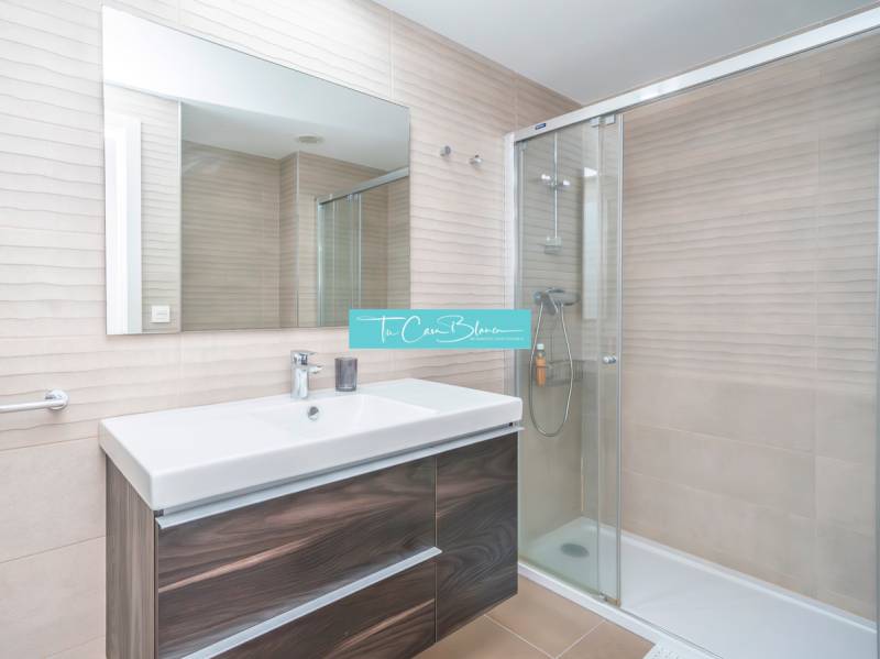 Bathroom in a 2-room apartment with a shower and a mirror above the sink.