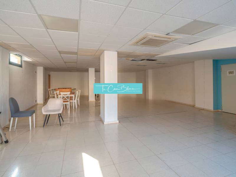 A spacious room with an armchair, a table, and chairs in a 2-room apartment.