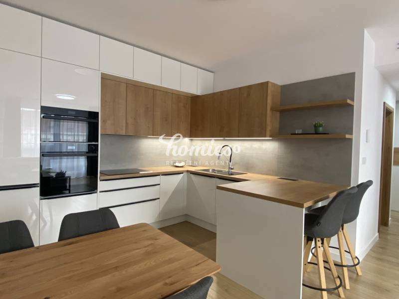 A kitchen in a 2-room apartment with a wooden decor floor and wooden details.