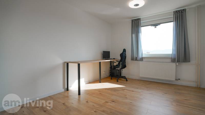 A room with a computer desk and a floor with a wooden decor in a 3-room apartment.