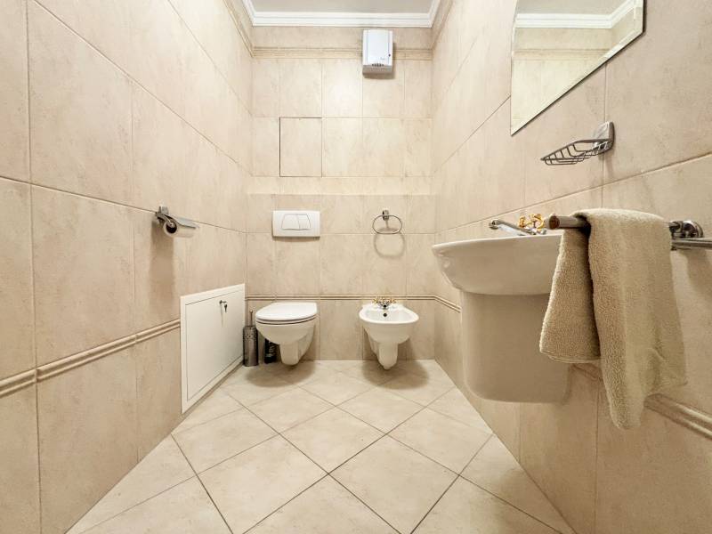 Bathroom in a 4-room apartment with tiles, sanitary equipment, and beige walls.