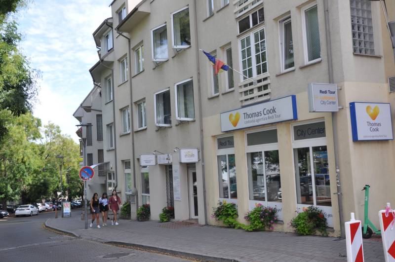 The building with a travel agency office on Zámocká in Bratislava, a group of people on the sidewalk.