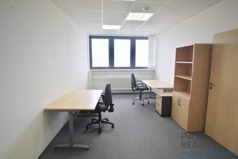 Offices with two desks and chairs, gray carpet, shelf.