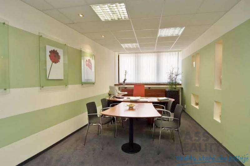 Offices with a desk, chairs, decorations placed on the walls, and a window with vertical blinds.