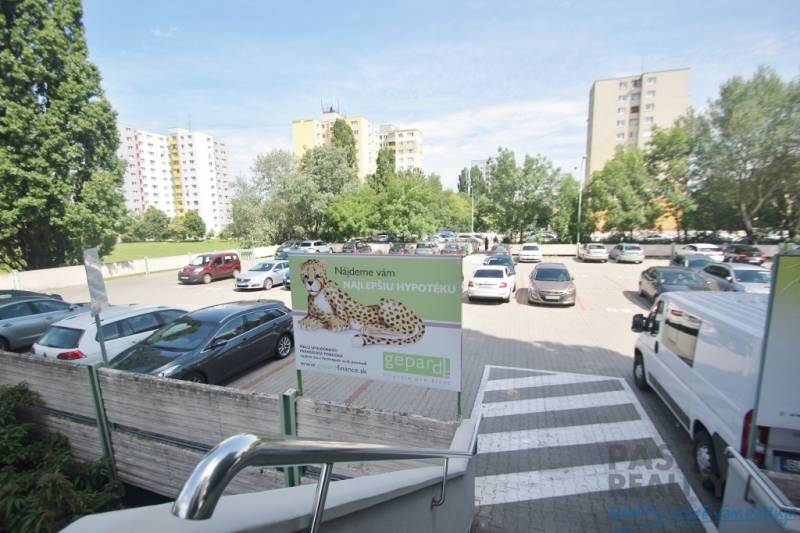 Parking lot on Kutlíkova Street in Bratislava - Meadows surrounded by greenery and apartment buildings.