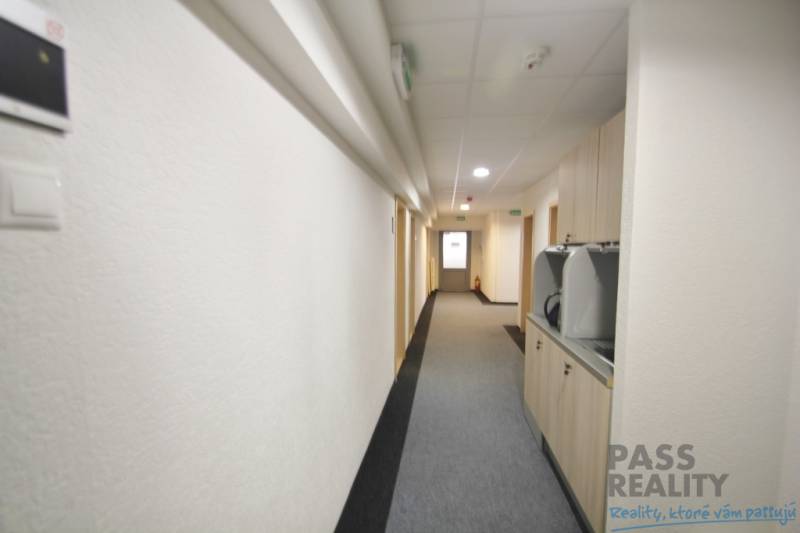 Offices with a narrow hallway and carpet, bright walls, and the bright Kutlíkova Street in Bratislava.