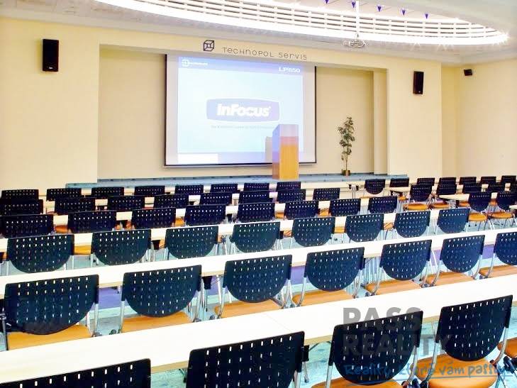 Conference room in offices with a projector and chairs, suitable for presentations.