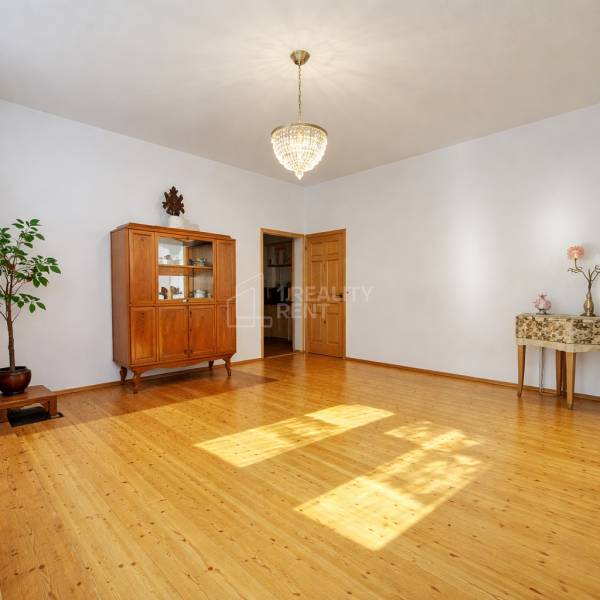 A family house with a chandelier, a wardrobe, and a wooden-decor floor in a spacious living room.