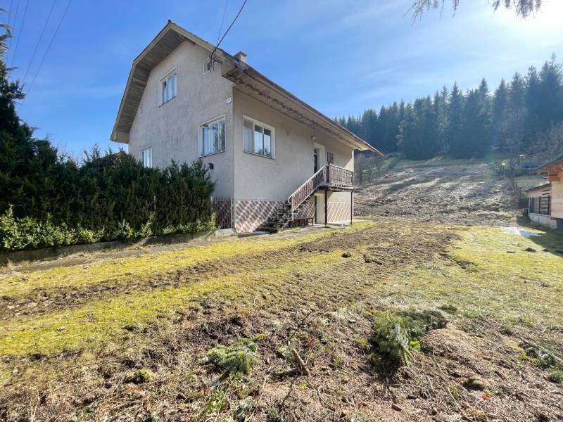 A family house in Terchová with a large grassy plot, surrounded by trees.