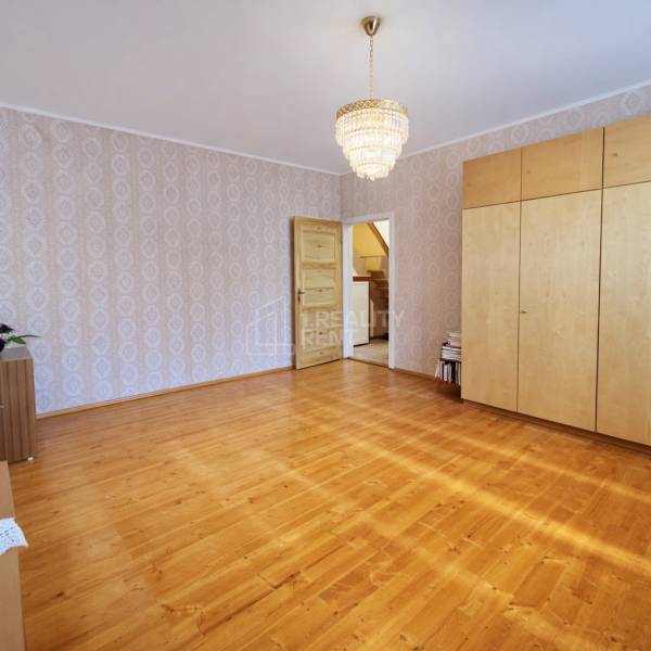 Interior of a family house with a wooden decor floor, chandelier, and built-in wardrobe.