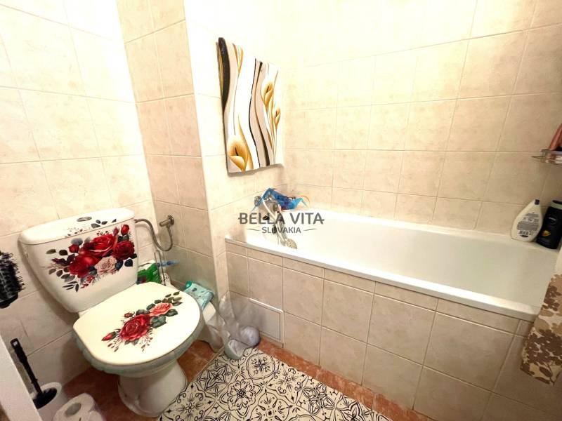 A bathroom with decorative tiles and a floral motif in a studio apartment.
