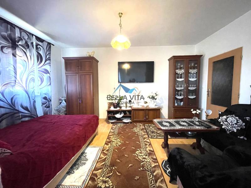 Living room in a one-room apartment with a wooden decor floor and furniture.