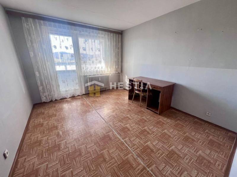 A room in a 3-room apartment with a wooden decor floor and large windows.