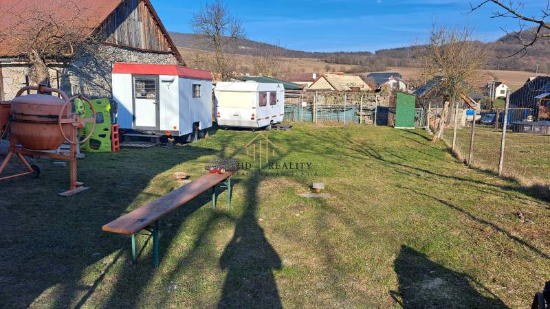 A building plot in Kráľovce Krnišov with a concrete mixer and trailers in the yard.