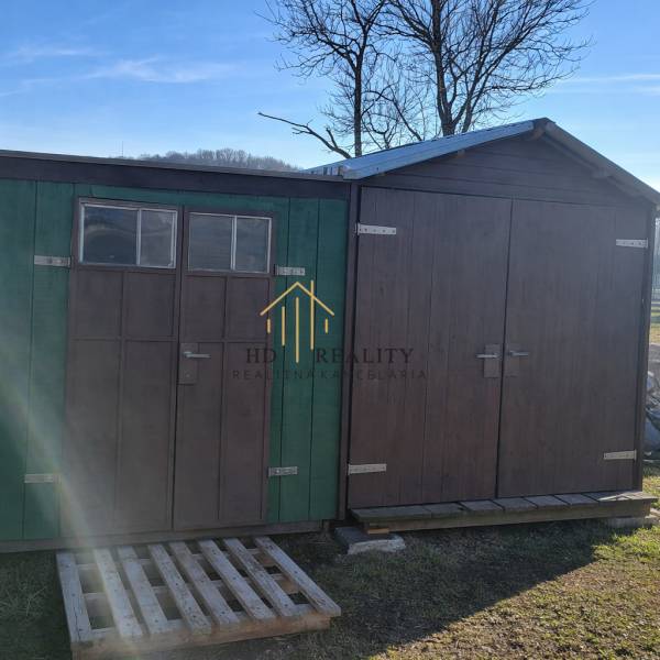 Wooden shelters and a pallet in the garden of the cottage in Kráľovce Krnišov.