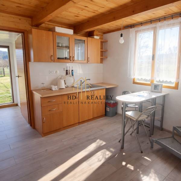 Kitchen in a cabin with wooden decor and furniture, sunny environment.