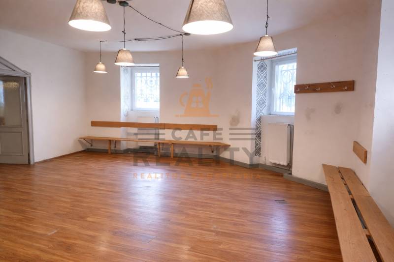 Commercial space with wood-patterned flooring, benches, and hanging lamps.