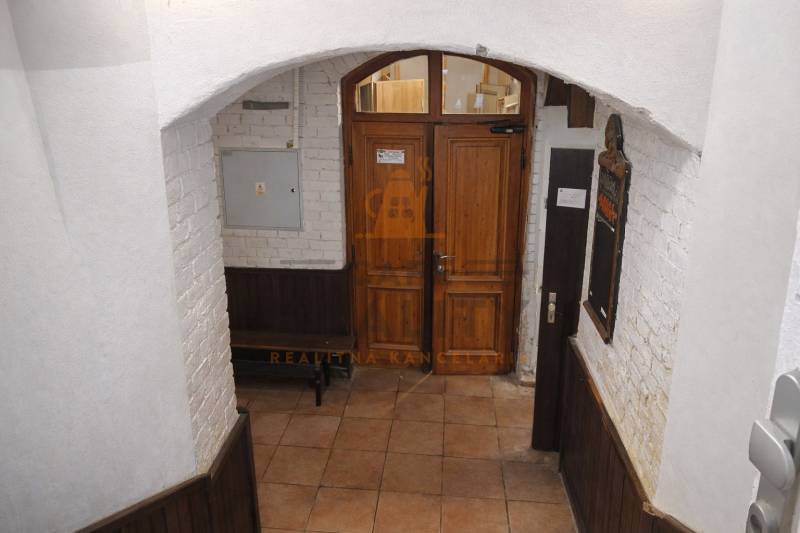 Entrance door in commercial premises with a brick wall and tiled floor.