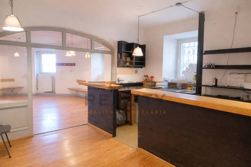 Commercial space with a bar counter and a wooden decor floor. Bright room with windows.