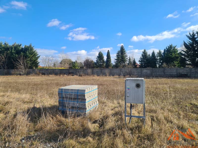 Building plot in Nové Zámky with concrete blocks and an instrument box, surrounded by greenery.