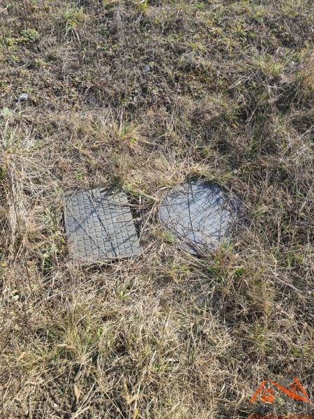 Plots - housing in Nové Zámky with manhole covers on the grassy area.