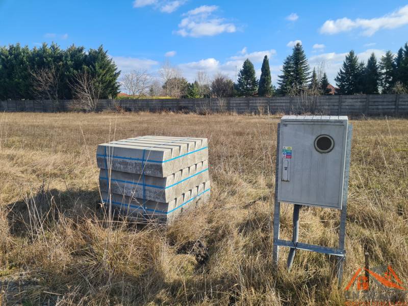 Building plot in Nové Zámky with concrete paving and an electrical cabinet.