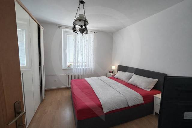 Bedroom with a bed and a cabinet, floor with wood decor, 3-room apartment.