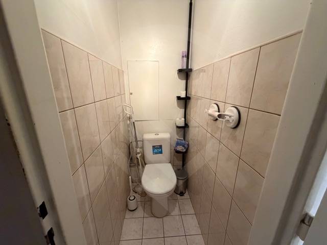 A toilet with tiles and cladding in a 3-room apartment.