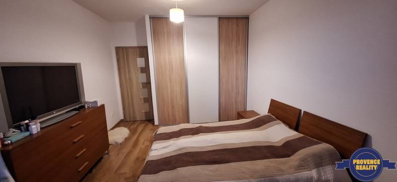 Bedroom in a 4-room apartment with wood-patterned flooring and a large wardrobe.