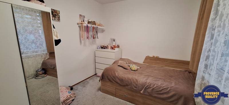 A bedroom in a 4-room apartment with a wardrobe, bed, and white dresser.