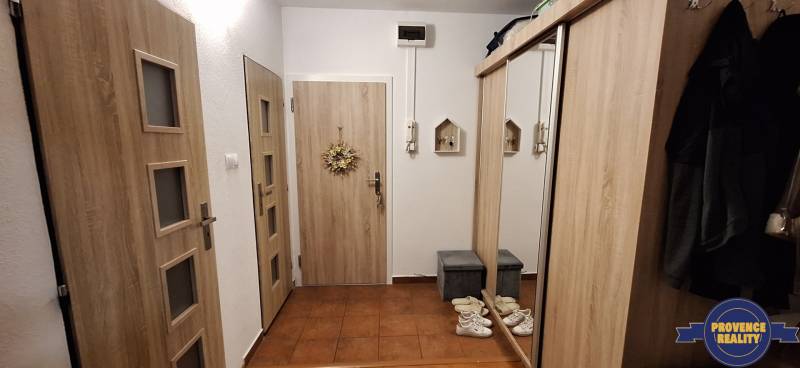 A hallway in a 4-room apartment with coat hooks and a mirrored wardrobe on a wooden-decor floor.