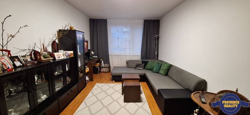 Living room in a 4-room apartment with a wooden decor floor and comfortable seating.