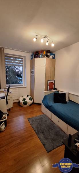 Children's room in a 4-room apartment with a bed, a desk, and a floor with a wooden decor.