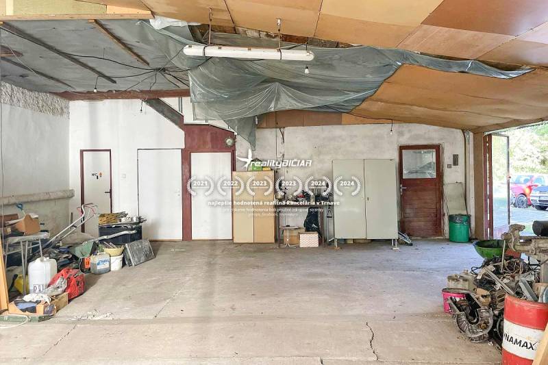The interior of a family house with a spacious area, stored items, and a cement floor.