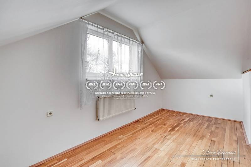 A room in a family house with a window and a wooden decor floor.