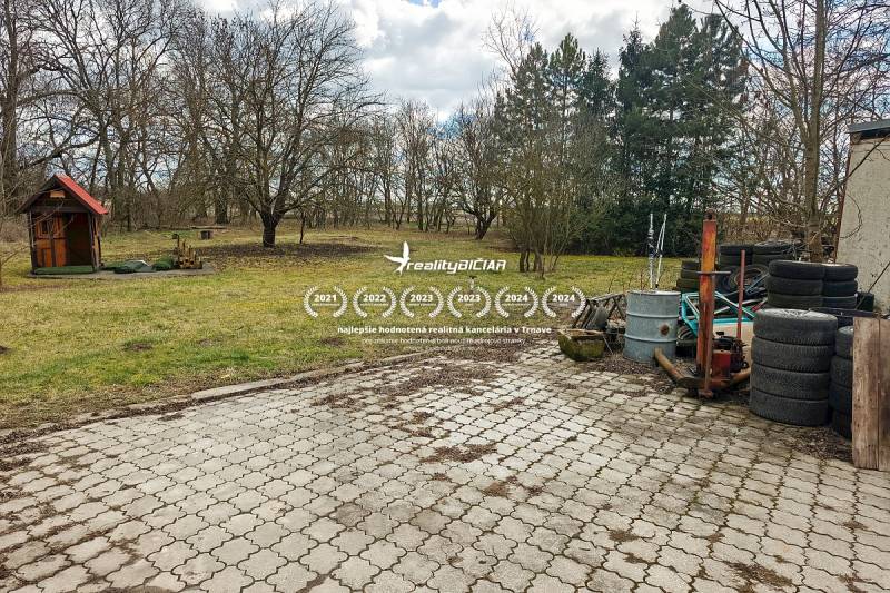 Pavlice, a family house in Pavlice with a paved courtyard, a shed, and a pile of tires.